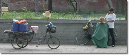 Man getting a haircut on the street in Beijing